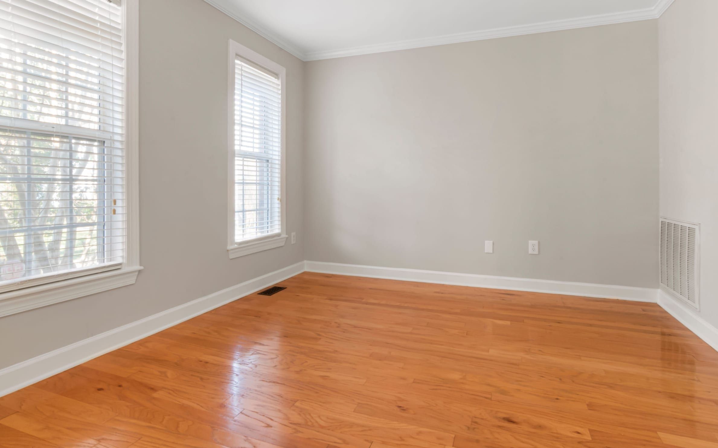 Empty freshly painted room with hardwood floors ready for a final walkthrough