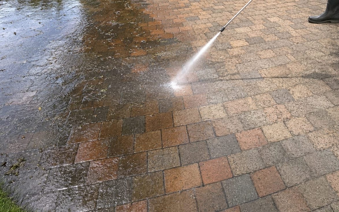 Pressure washing pavers with a sharp line between clean and dirty halves