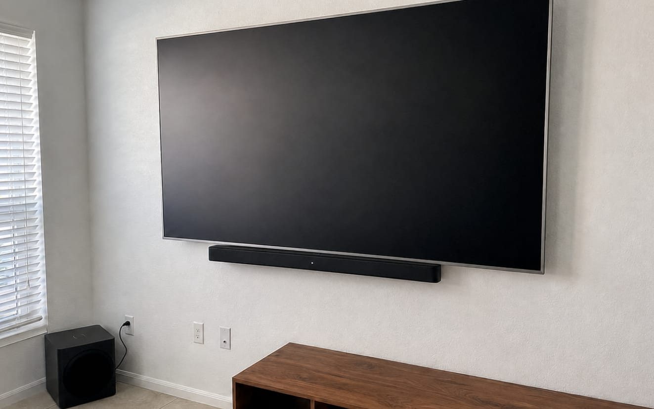 Large flat-screen TV with a soundbar mounted beneath it and no visible cords